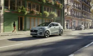 Jasnoszary Ford Puma jedzie ulicą miasta. Sprawdź aktualną ford puma cena i możliwości tego stylowego SUV-a.