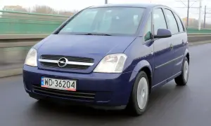 Niebieski Opel Meriva B jedzie po moście.