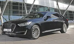 Elegancki, czarny Genesis G90 lśni przed nowoczesnym budynkiem.