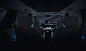 Wnętrze nowego Toyota Highlander nocą, z niebieskim nastrojowym oświetleniem i dużym ekranem multimedialnym.