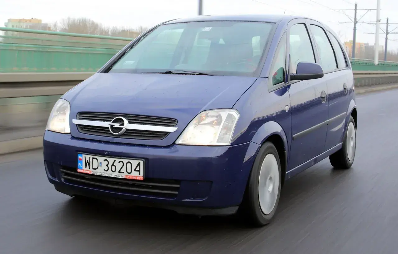 Niebieski Opel Meriva B jedzie po moście.