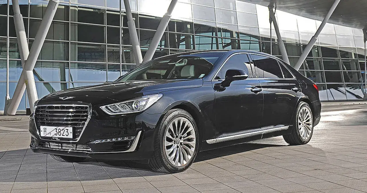 Elegancki, czarny Genesis G90 lśni przed nowoczesnym budynkiem.