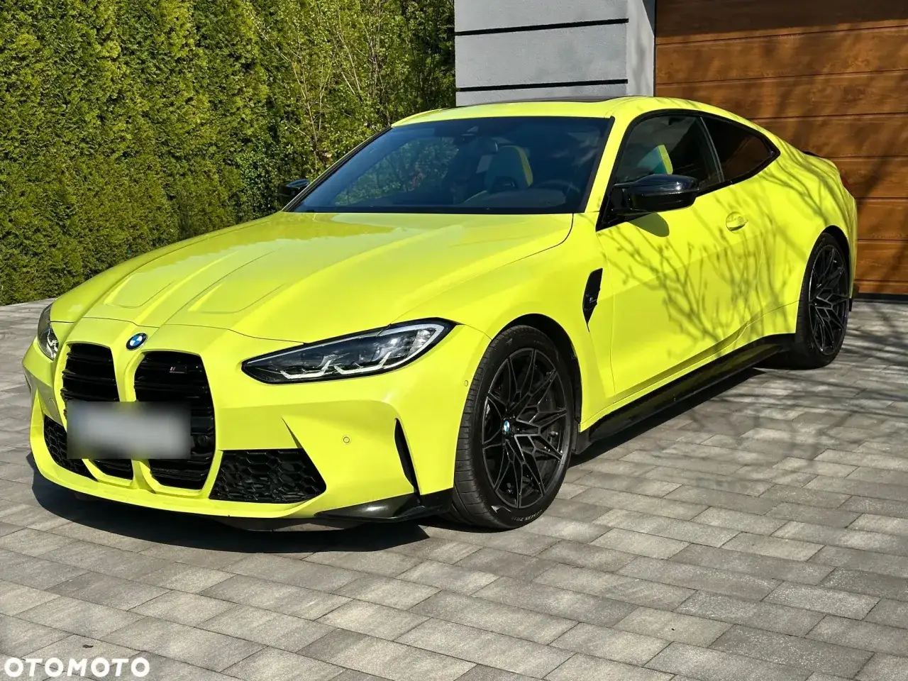 Jaskrawożółte BMW M4 na podjeździe. Sprawdź aktualną bmw m4 cena i znajdź swoją wymarzoną wersję.