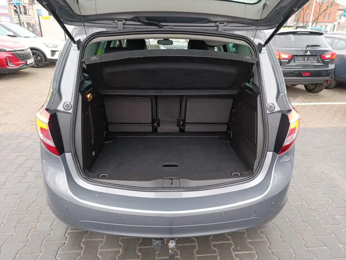 Szary Opel Meriva B z otwartym bagażnikiem. Wnętrze jest puste, gotowe na bagaże.