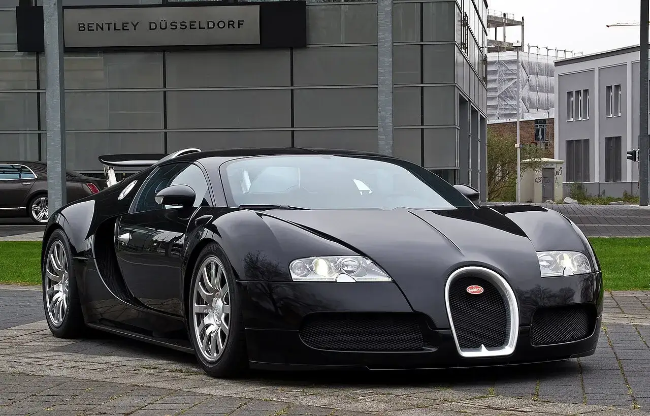 Czarny Bugatti Veyron przed salonem Bentley Düsseldorf. Zastanawiasz się nad bugatti veyron cena?