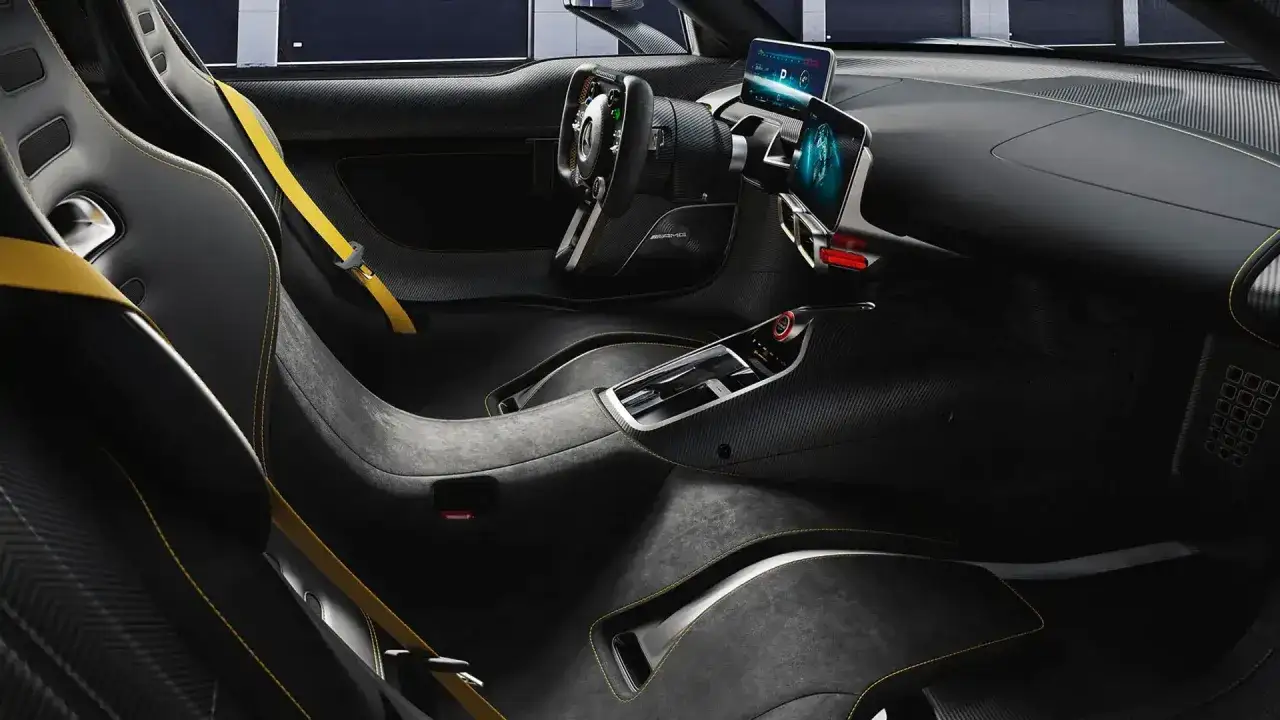 Wnętrze Mercedes-AMG ONE: sportowe fotele, żółte pasy, cyfrowe ekrany i kierownica F1.