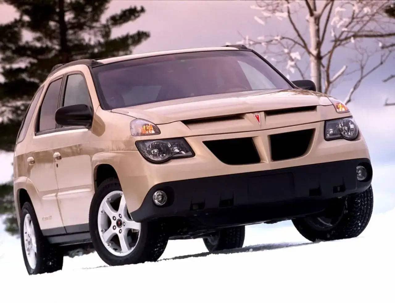 Beżowy Pontiac Aztek na śniegu, gotowy na zimową przygodę.