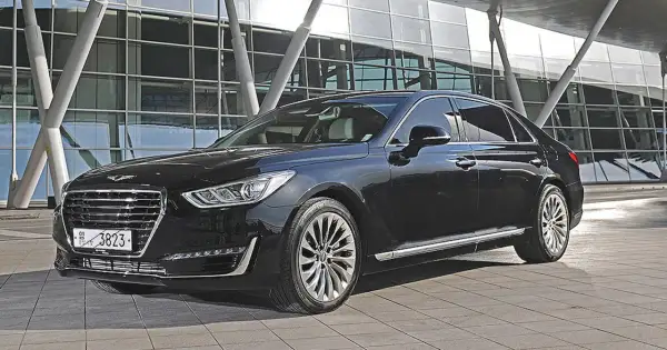 Elegancki, czarny Genesis G90 lśni przed nowoczesnym budynkiem.