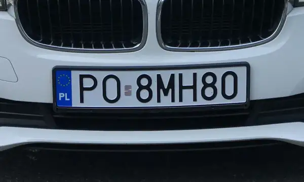 Białe auto z polską tablicą rejestracyjną PO 8MH80.