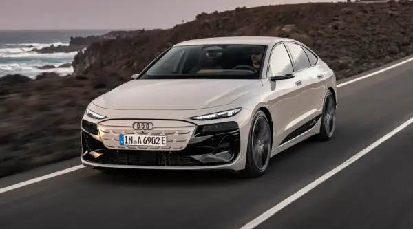 Elegancki Audi A6 e-tron sunie po malowniczej drodze nad oceanem.
