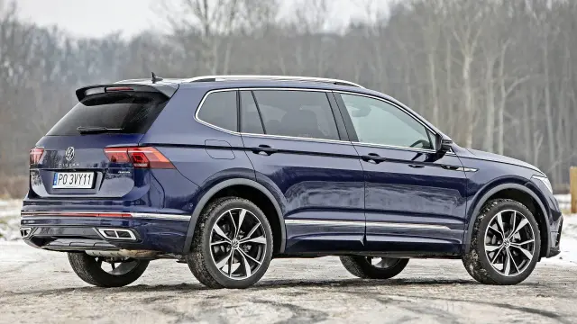 Tiguan wymiary: ciemnoniebieski SUV z przyciemnianymi szybami i chromowanymi listwami, stoi na drodze.